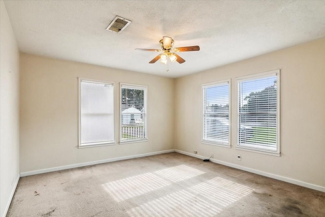 unfurnished room with ceiling fan, light colored carpet, and a textured ceiling