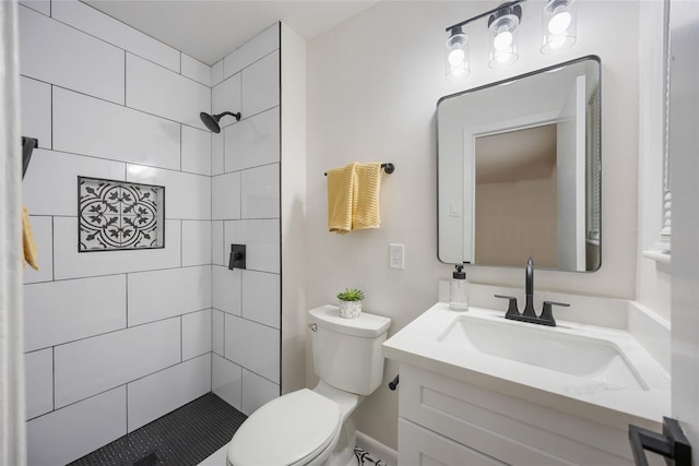 bathroom with vanity, toilet, and a tile shower