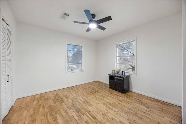 unfurnished bedroom featuring ceiling fan, a closet, and light wood-type flooring