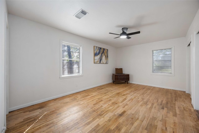 empty room with ceiling fan and light hardwood / wood-style floors