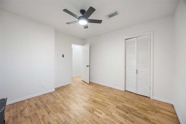 unfurnished bedroom featuring a closet, light hardwood / wood-style floors, and ceiling fan