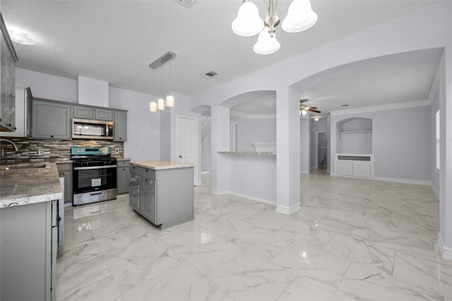 kitchen featuring gray cabinets, decorative light fixtures, a kitchen island, and stainless steel appliances