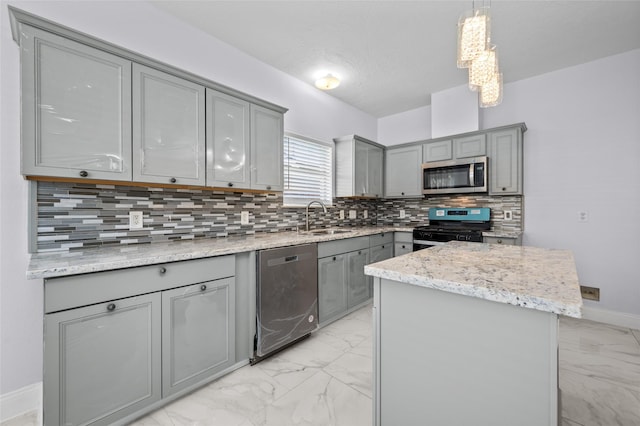 kitchen featuring decorative light fixtures, stainless steel appliances, a kitchen island, and gray cabinetry