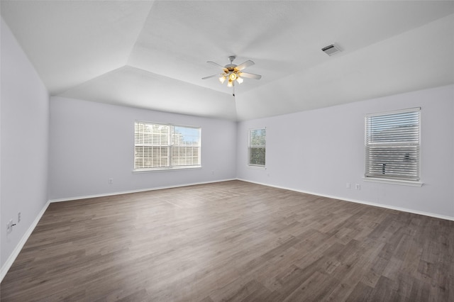 spare room with ceiling fan, dark wood-type flooring, and vaulted ceiling