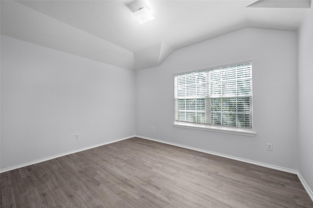 empty room featuring hardwood / wood-style floors and vaulted ceiling