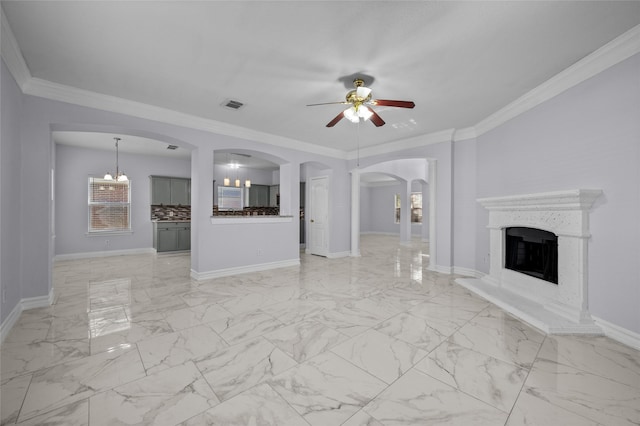 unfurnished living room featuring ceiling fan with notable chandelier and crown molding