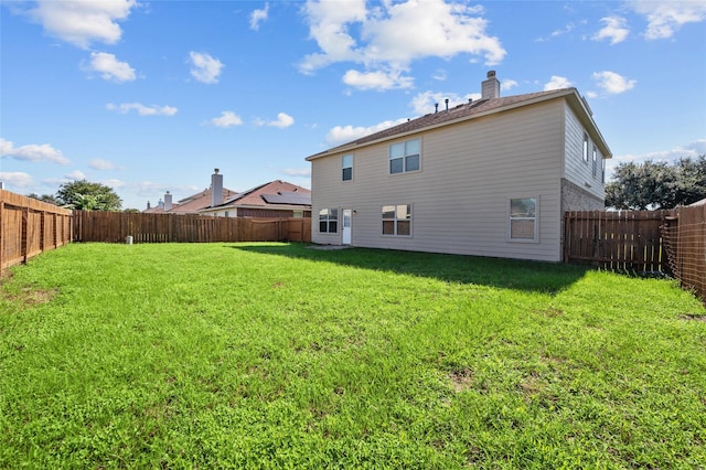 rear view of property featuring a yard