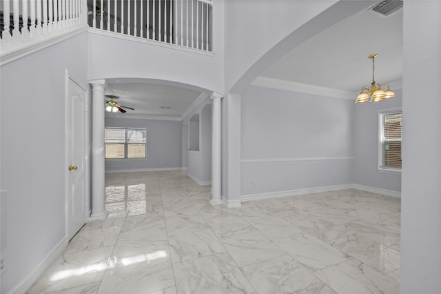 entrance foyer featuring ceiling fan with notable chandelier, ornate columns, crown molding, and a towering ceiling