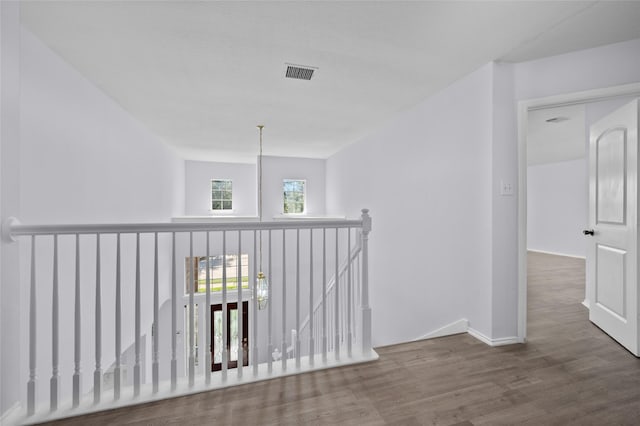 hall with hardwood / wood-style flooring and an inviting chandelier