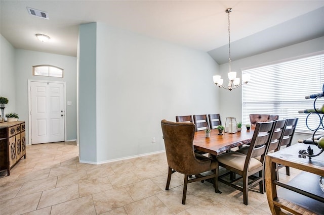 tiled dining space with a chandelier and lofted ceiling