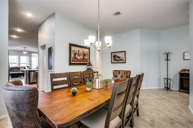 tiled dining room with ceiling fan with notable chandelier