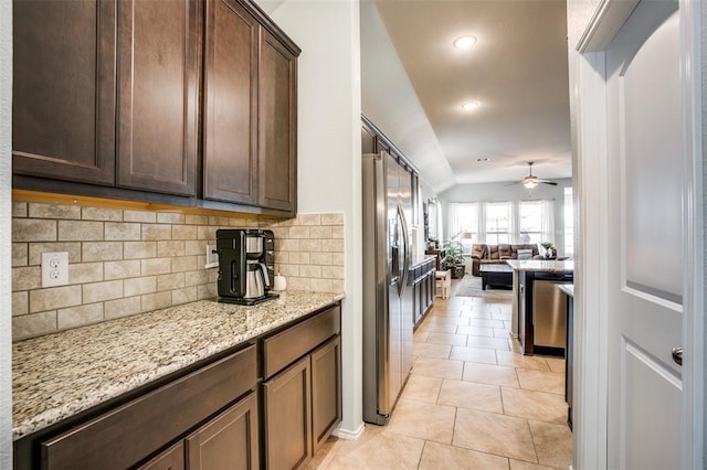 kitchen featuring ceiling fan, stainless steel appliances, tasteful backsplash, light stone counters, and light tile patterned flooring