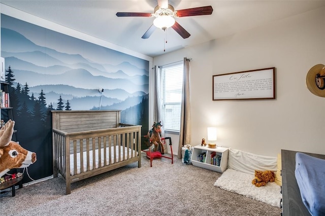 bedroom featuring a crib, carpet floors, and ceiling fan