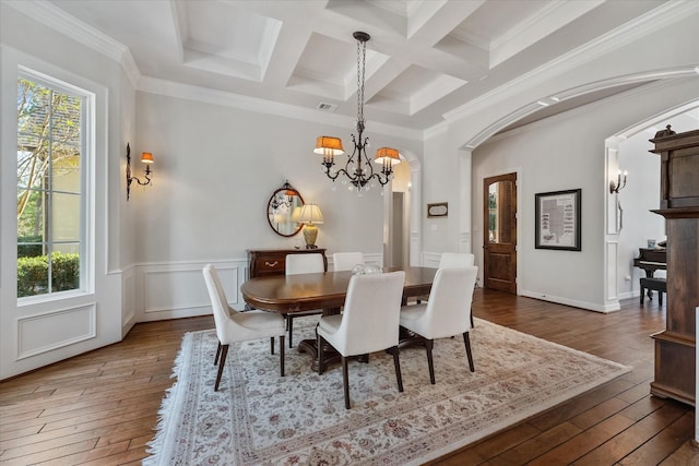 dining room with beamed ceiling, ornamental molding, dark wood-type flooring, and coffered ceiling