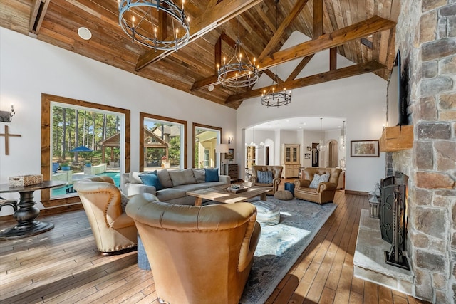 living room featuring beamed ceiling, a notable chandelier, hardwood / wood-style floors, and high vaulted ceiling