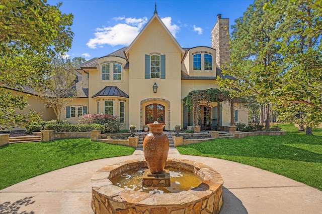 french country style house featuring a front yard and french doors