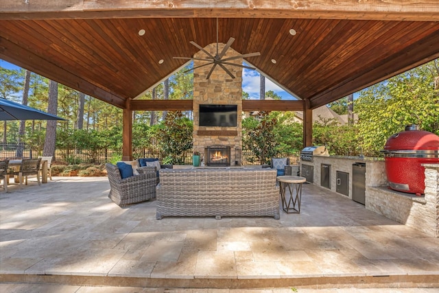 view of patio / terrace with a gazebo, grilling area, an outdoor living space with a fireplace, and an outdoor kitchen