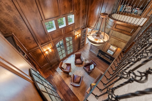 living room featuring a high ceiling, coffered ceiling, sink, wooden walls, and wood-type flooring