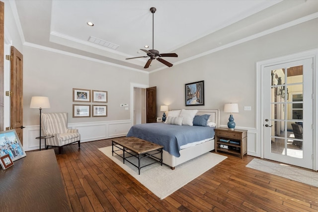 bedroom featuring a raised ceiling, ceiling fan, dark hardwood / wood-style floors, and ornamental molding