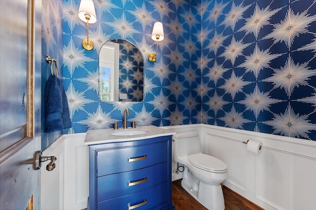 bathroom with hardwood / wood-style floors, vanity, and toilet