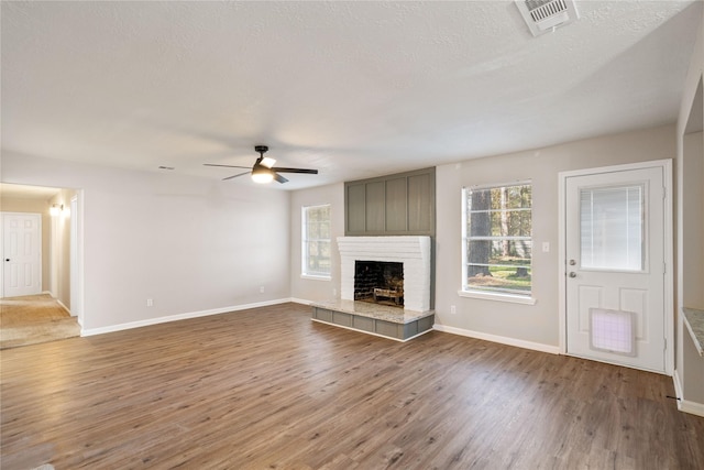 unfurnished living room featuring wood-type flooring, a textured ceiling, and ceiling fan