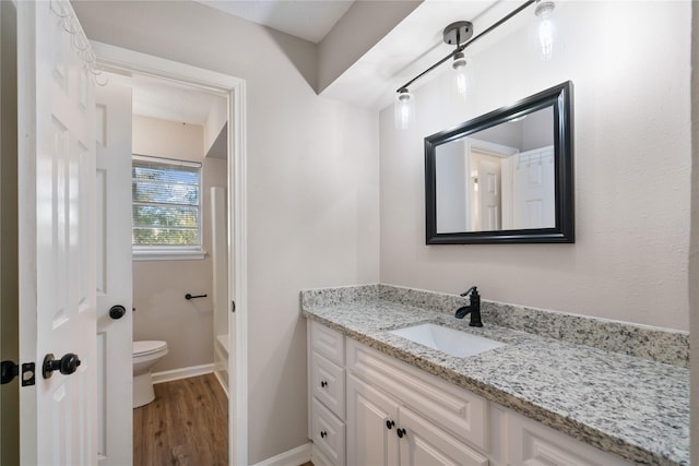 bathroom with hardwood / wood-style floors, vanity, and toilet