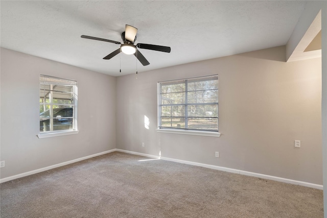 carpeted spare room featuring ceiling fan, a healthy amount of sunlight, and a textured ceiling