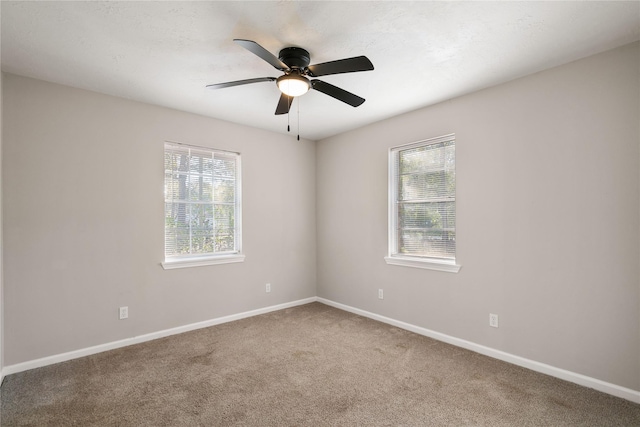 carpeted spare room featuring ceiling fan