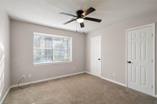 carpeted empty room featuring a textured ceiling and ceiling fan