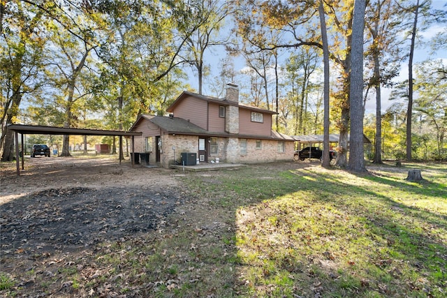 rear view of property featuring a carport, a lawn, and central air condition unit