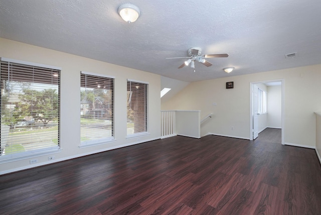 interior space featuring lofted ceiling, ceiling fan, dark wood-type flooring, and a textured ceiling