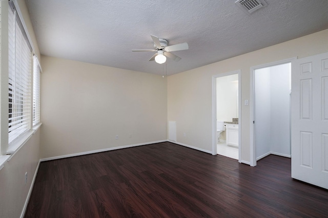 spare room with a textured ceiling, dark hardwood / wood-style flooring, and ceiling fan