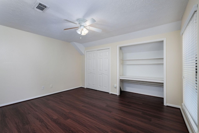 unfurnished bedroom with ceiling fan, dark hardwood / wood-style flooring, and a textured ceiling