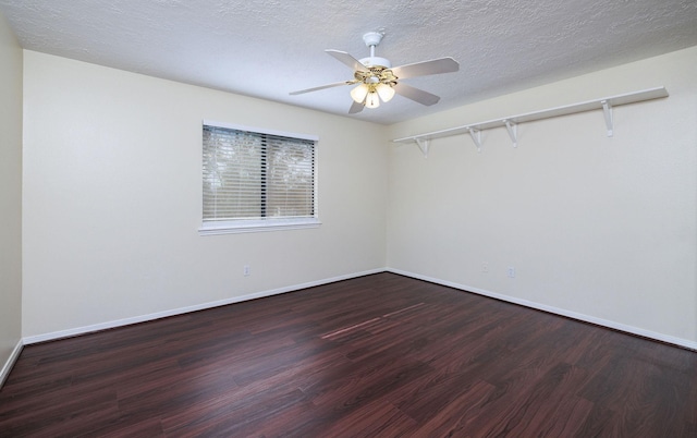 unfurnished room with ceiling fan, dark wood-type flooring, and a textured ceiling