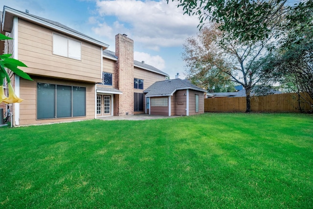 back of property featuring a lawn and a storage unit