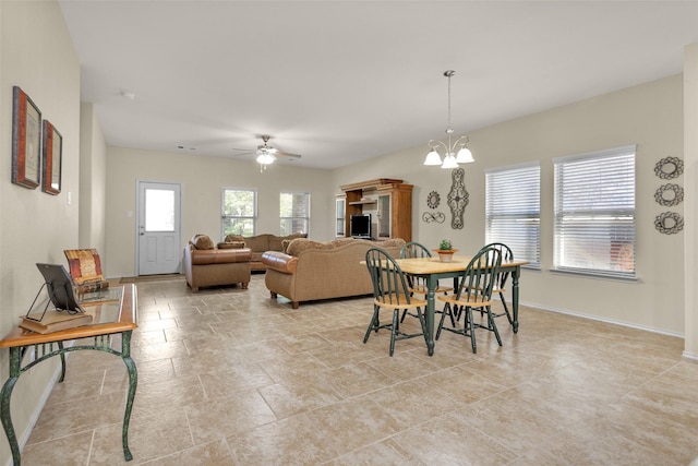 dining space with ceiling fan with notable chandelier