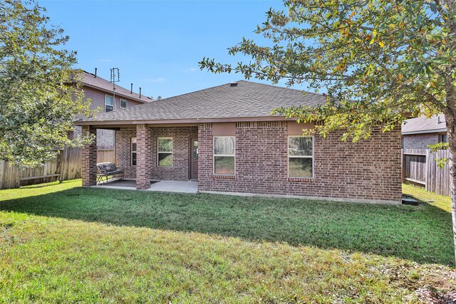 rear view of house with a lawn and a patio area