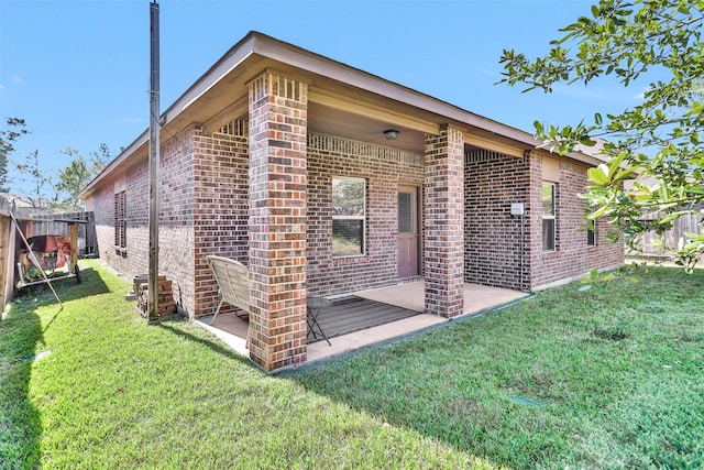 back of property featuring a yard and a patio