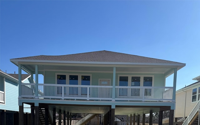 rear view of house with a carport, a balcony, and covered porch