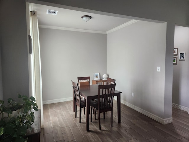 dining room with dark hardwood / wood-style floors and ornamental molding