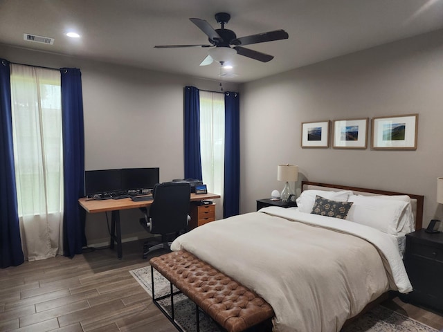 bedroom featuring multiple windows, dark hardwood / wood-style flooring, and ceiling fan