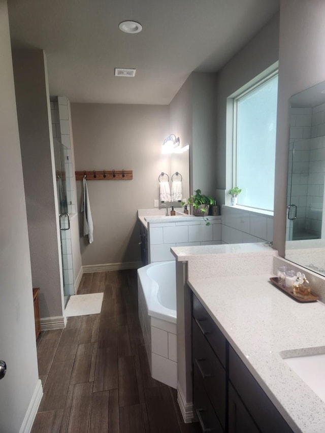 bathroom featuring vanity, independent shower and bath, and hardwood / wood-style flooring