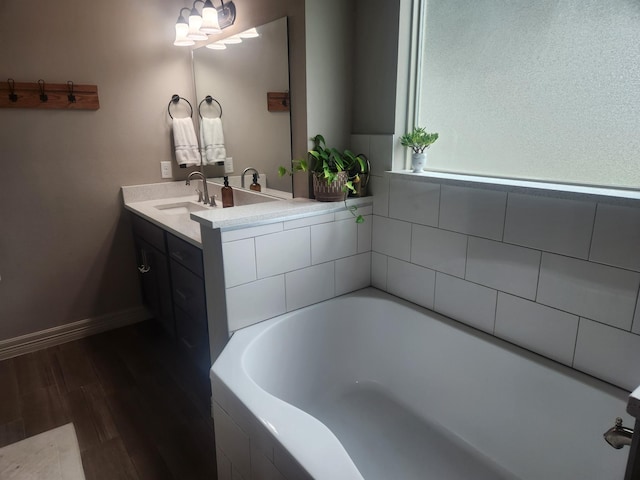 bathroom featuring vanity, wood-type flooring, and tiled bath