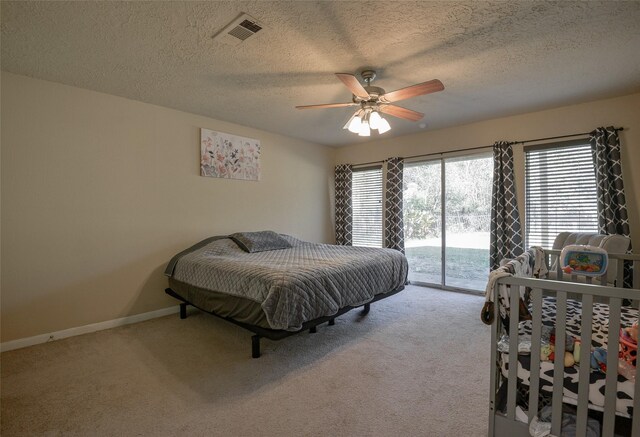 carpeted bedroom featuring ceiling fan, access to exterior, and a textured ceiling