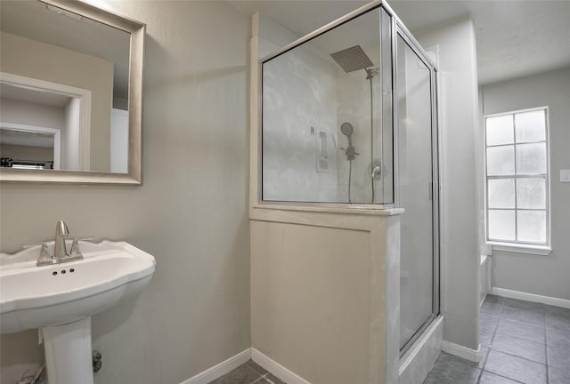 bathroom featuring tile patterned flooring, a shower with door, and sink