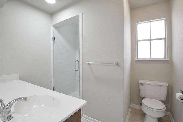 bathroom featuring tile patterned floors, vanity, toilet, and a shower with shower door