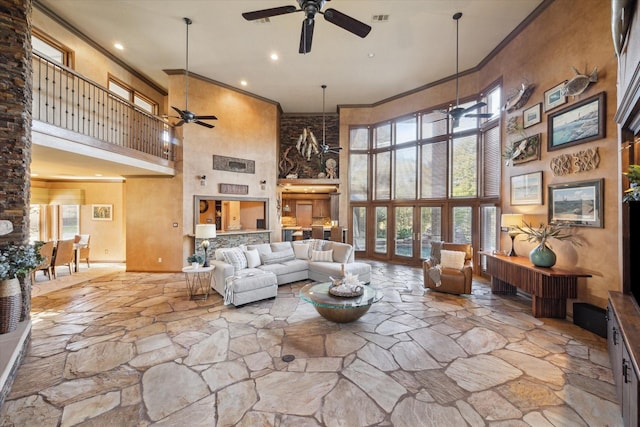 living room with a wealth of natural light, ceiling fan, and a high ceiling