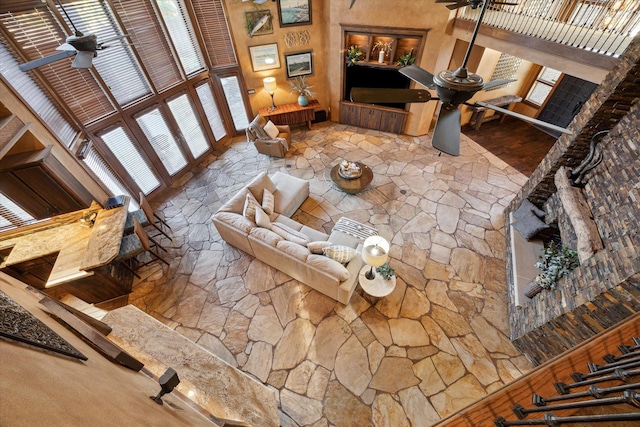 living room with a towering ceiling and ceiling fan