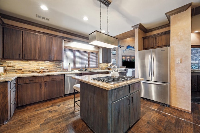 kitchen featuring dark brown cabinets, a kitchen island, pendant lighting, and appliances with stainless steel finishes