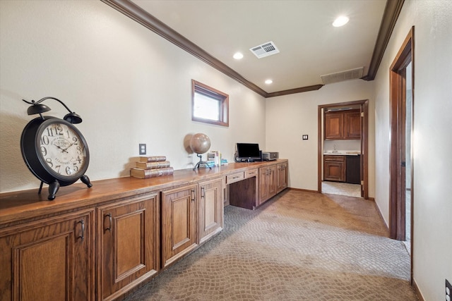 office featuring light carpet, built in desk, crown molding, and sink